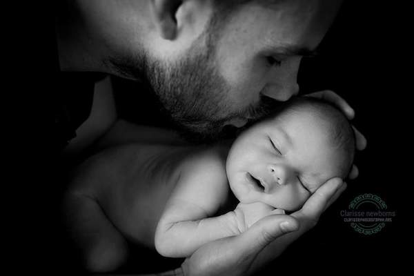 Dad kissing baby in newborn photoshoot
