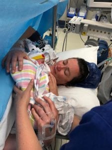 Stacey holding her baby after a caesarean birth