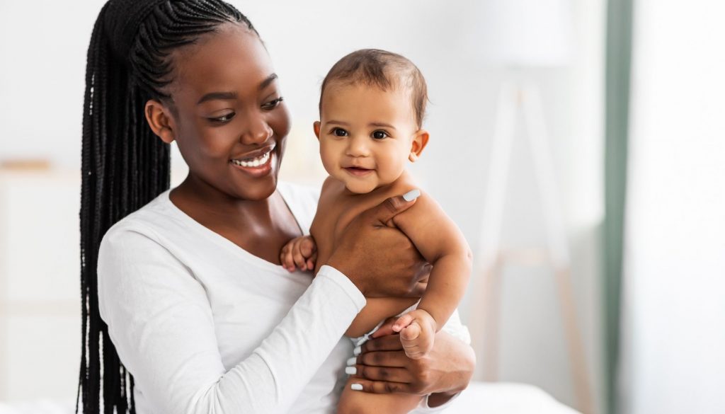 African American Mom Hugging Her Cute Infant and Posing