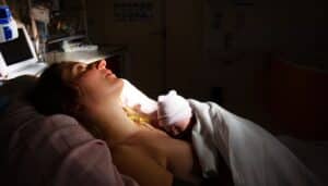 Newborn baby in women's hands after birth