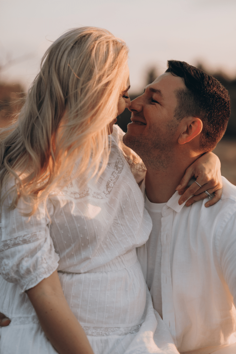 Pregnant couple embracing and about to kiss