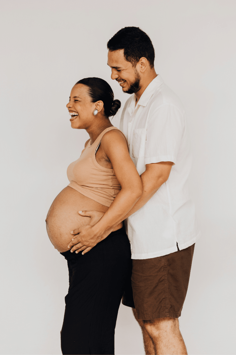 Hypnobirthing Australia™ Affiliate Program - Happy Pregnant Couple laughing as husband hold pregnant belly