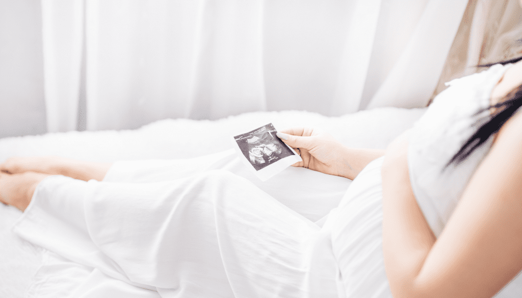 pregnant women looks at ultrasound photo